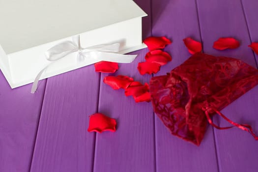 Rose petals and gift box with ribbon