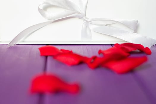 Rose petals and gift box with ribbon