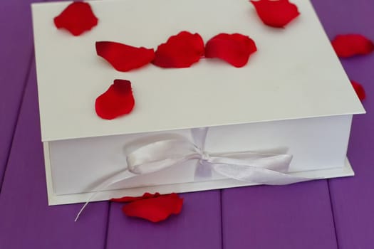 Rose petals and gift box with ribbon