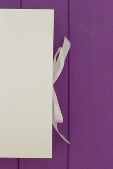 White box on the tie on a purple wooden background. Mocap