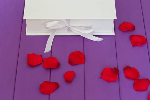 Rose petals and gift box with ribbon