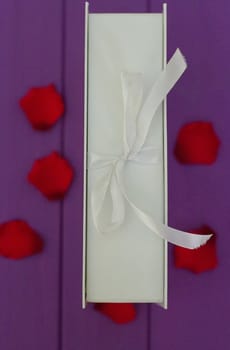 Rose petals and gift box with ribbon