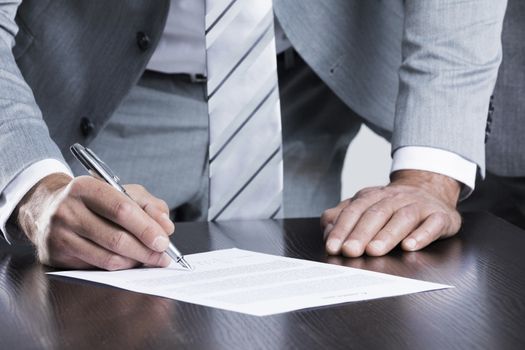 Business man sign contract standing near the table