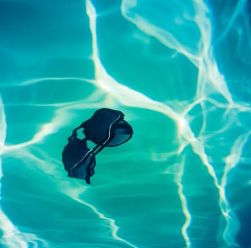 Retro Style Image Of Sunglasses Falling Into A Swimming Pool