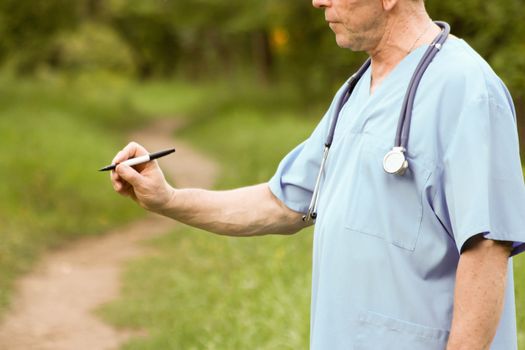 Doctor and nature concept. THE DOCTOR KEEPS MARKER IN THE HAND TO THE PROFILE. Photo horizontal for your design.