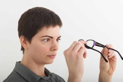 Surprised woman looking at her glasses. Stressed shocked businesswoman. Negative human face expressions, emotion feeling body language reaction.