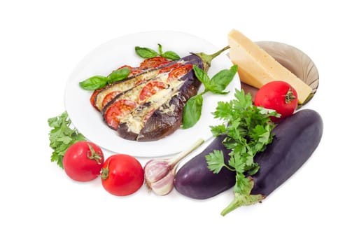 Baked eggplant stuffed with vegetables and cheese decorated with basil leaves on white dish and ingredients for its cooking beside on a white background
