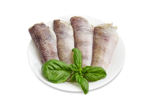 Several uncooked carcasses of the notothenia fish without of a heads and tails and with peeled scales and prepared for cooking, twigs of basil on the white dish on a white background
