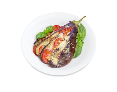 Baked eggplant stuffed with vegetables and cheese decorated with basil leaves on white dish on a white background
