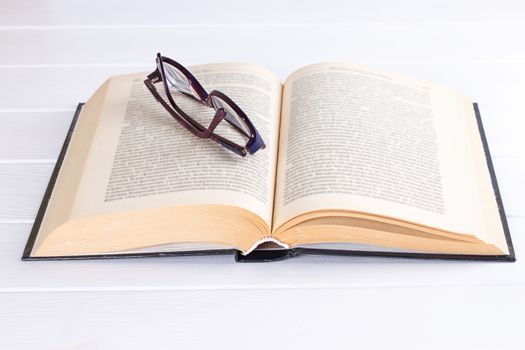 glasses and book on the white background