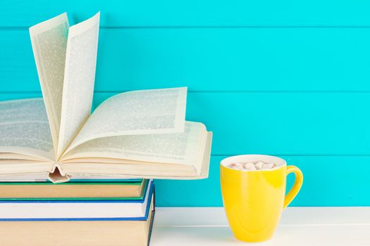 Stack of books on wooden table with a cup of tea. Education background. Copy space for text.