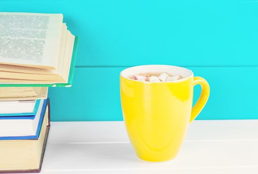 Stack of books on wooden table with a cup of tea. Education background. Copy space for text.