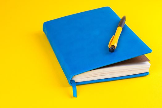 blue Daily planner with colored bookmarks. yellow background.