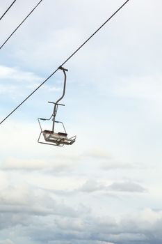 Empty chairlift with blue sky in the background. Cableway chairlift