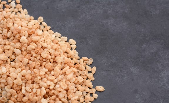 Crisped rice breakfast cereal in a border line with copy space on a dark grey slate tile background