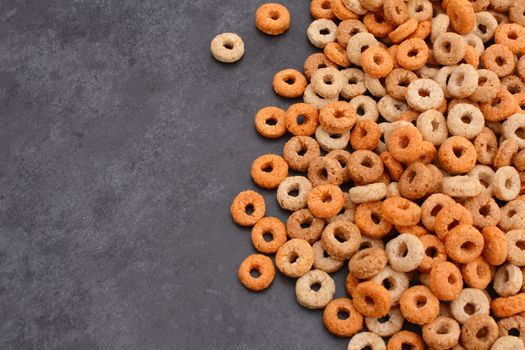 Multigrain hoops breakfast cereal in a border line with copy space on a dark grey slate tile background