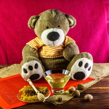 Plush bear with a vase and a spoon for honey and nuts