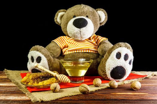 Plush bear with a vase and a spoon for honey and nuts