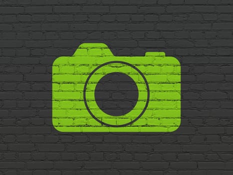 Travel concept: Painted green Photo Camera icon on Black Brick wall background