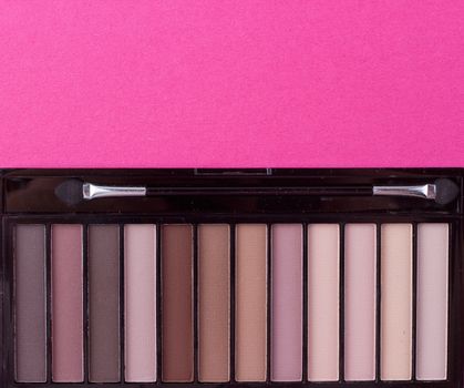 Set of nude eyeshadows in black case on pink background