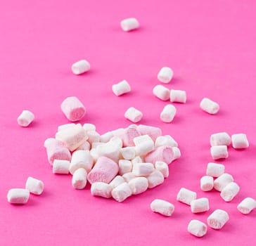 Colored twisted marshmallow on the pink background