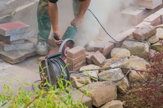 Man cutting stone slabs, concrete slab with an electric grinder