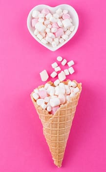 Marshmallows ice-cream and waffle cones on a pink background