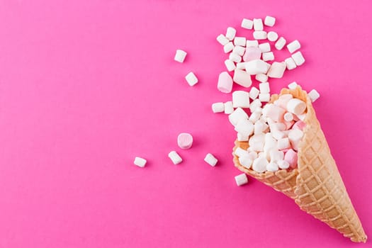 Marshmallows ice-cream and waffle cones on a pink background