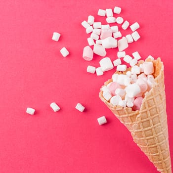 Marshmallows ice-cream and waffle cones on a pink background