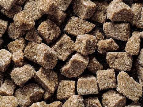 natural raw brown cane sugar cubes close up as background. Top view of brown sugar pattern.