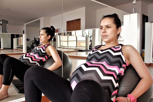 pregnant woman exercise with a ball at the gym