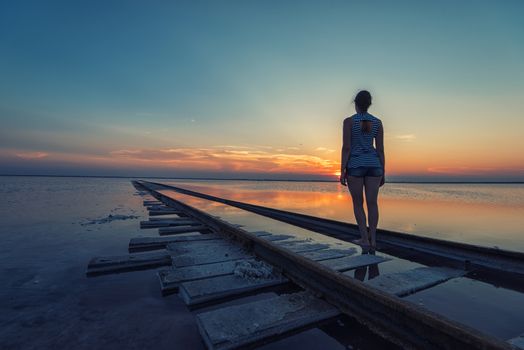 Woman at beauty sunset on salty lake