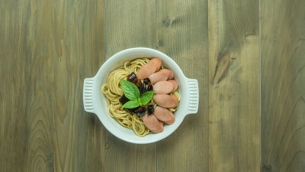 Spaghetti with sausage  and dried peppers , hot and spicy on wooden background, top view