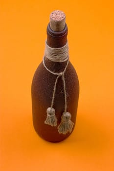 brown bottle made of stone on an orange background