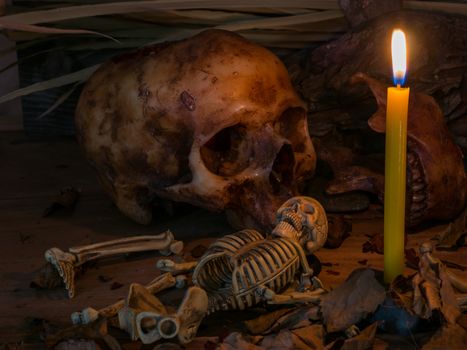 Candle with skull and apple on wood table background,Still life