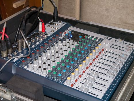 Professional audio mixing console with faders and adjusting knobs