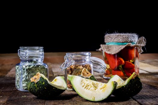 Tasty pumpkin and spices on a wooden kitchen table, black background