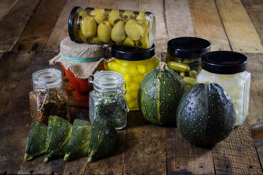 Pumpkin jars and spices. Preparations from your own garden. Wooden kitchen table. Black background.