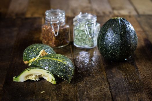 Tasty pumpkin and spices on a wooden kitchen table, black background