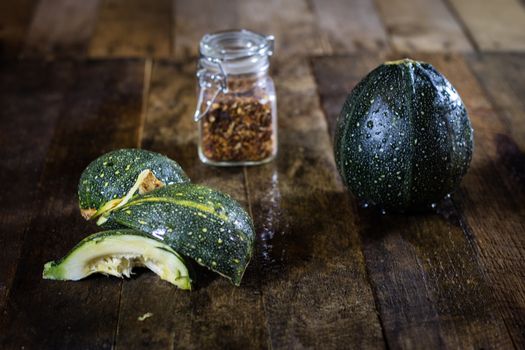 Tasty pumpkin and spices on a wooden kitchen table, black background