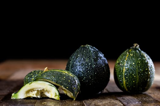 Tasty mini pumpkin on a wooden table, black background