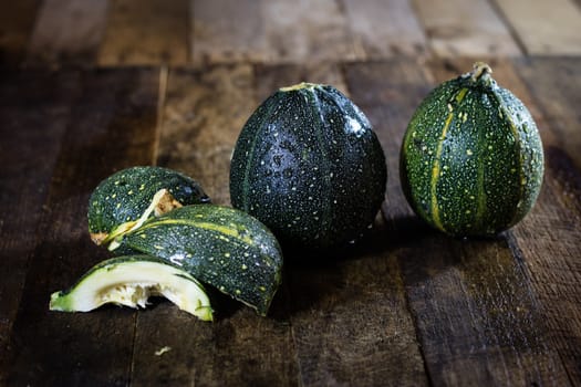 Tasty mini pumpkin on a wooden table, black background