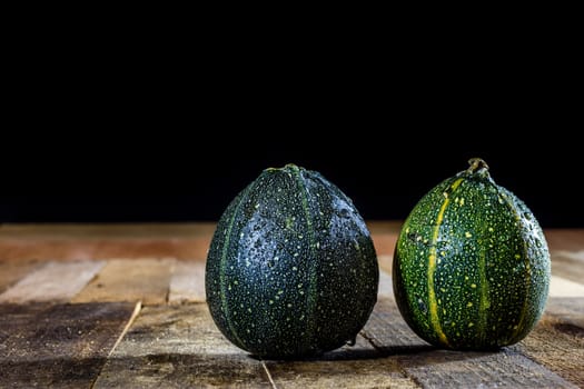 Tasty mini pumpkin on a wooden table, black background