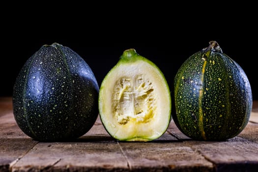 Tasty mini pumpkin on a wooden table, black background