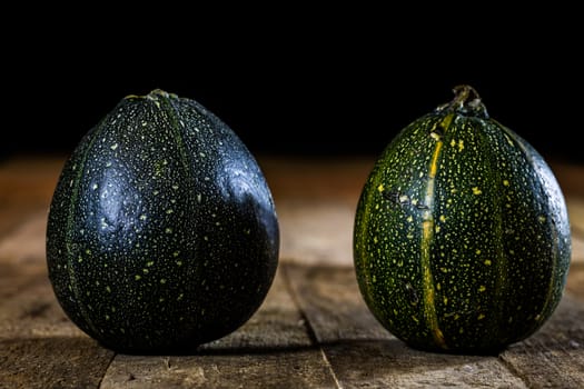 Tasty mini pumpkin on a wooden table, black background