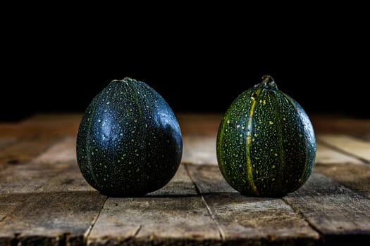 Tasty mini pumpkin on a wooden table, black background