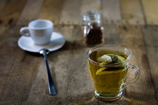 Tasty tea with nettles on a wooden table, black background