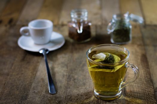 Tasty tea with nettles on a wooden table, black background