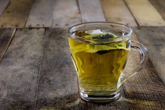 Tasty tea with nettles on a wooden table, black background