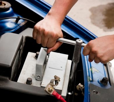 Mechanic at work, process of changing the car battery, closeup shot